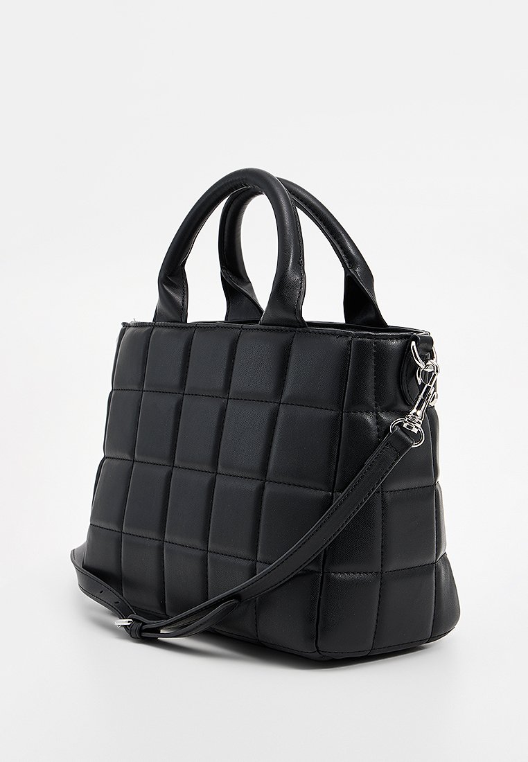 Schwarze gesteppte Lederhandtasche mit zwei kurzen Griffen und einem abnehmbaren Schultergurt auf weißem Hintergrund.