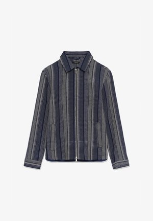 Marineblauwe jas met verticale witte gestippelde strepen, ritssluiting aan de voorkant, twee zijzakken en een puntkraag.