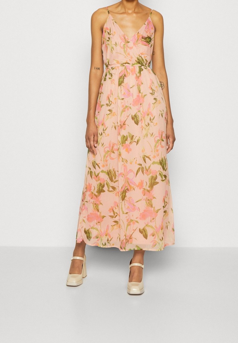 Robe longue fleurie en tissu rose doux, dotée d'un décolleté en V, de fines bretelles et d'une taille cintrée. Décorée de motifs floraux verts et roses.