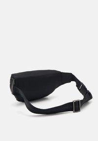 Mustat vyölaukku, joka on valmistettu sileästä kankaasta, varustettu vetoketjulla, säädettävällä hihnalla ja tyylikkäällä, muotoillulla designilla. Minimalistinen muotoilu.