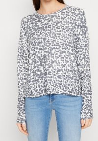 Pitkähihaisen paidan leopardikuosiset harmaat sävyt valkoisella pohjalla. Pehmeä kangas, pyöreä pääntie, rento malli ja pidennetyt hihansuut.