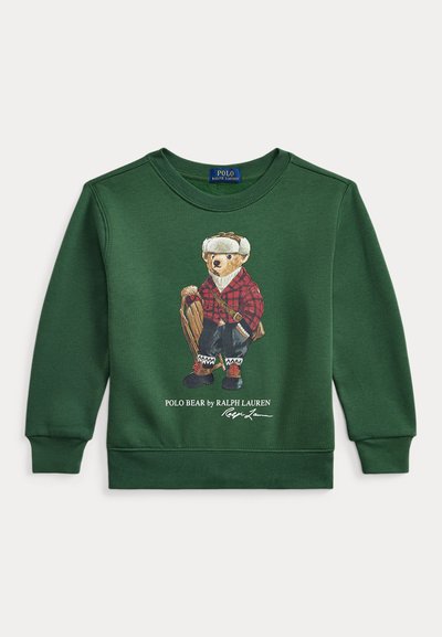 Grønn genser med en bjørn i rutete antrekk, med grafiske detaljer og ribbede mansjetter. Logotekst nederst, avslappet design.