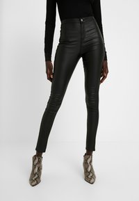 Svarta högmidjade byxor i konstläder med en smal passform, med en knappstängning fram och subtil lyster. Bärs med ankelboots i ormskinn.