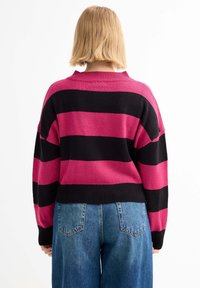 Suéter de punto con rayas horizontales en rosa brillante y negro. Cuello y puños acanalados, diseño ligeramente corto. Ajuste casual.