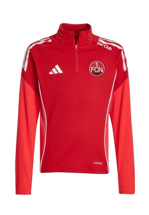 Camiseta deportiva Adidas de manga larga roja con el logo del club 1. FCN, rayas blancas en los hombros, cuello con cremallera hasta la mitad y texto "Der Club" cerca del cuello.