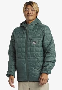 Green quilted puffer jacket with a hood, zippered chest pocket, and two side pockets, featuring a smooth, shiny texture and elastic cuffs.