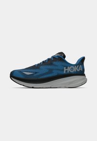 Scarpa da corsa da uomo con tomaia in mesh blu e nera, logo prominente di lato, intersuola bianca ammortizzata e suola nera testurizzata.