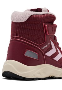 Bordowe buty turystyczne z teksturowanego materiału, różowymi akcentami i rzepem. Posiadają wyściełany kołnierz i solidną czarną podeszwę.