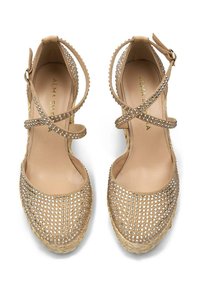 Beige espadrille platform shoes with crossed ankle straps, adorned with silver rhinestones, featuring a textured jute sole and smooth leather insole.