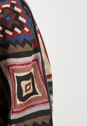 Tela multicolor con patrones geométricos en rojo, negro, azul y beige con textura y un ribete negro contrastante.