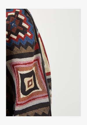 Tela multicolor con patrones geométricos en rojo, negro, azul y beige con textura y un ribete negro contrastante.