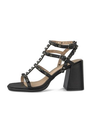 Sandalia negra de tacón alto con tacón de bloque, múltiples tiras delgadas adornadas con tachuelas y dos cierres ajustables con hebilla.