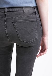 Grå denimjeans med smal passform, som har en distinkt bakfickdesign, subtil sömnad och en märkesläderlapp vid midjan.