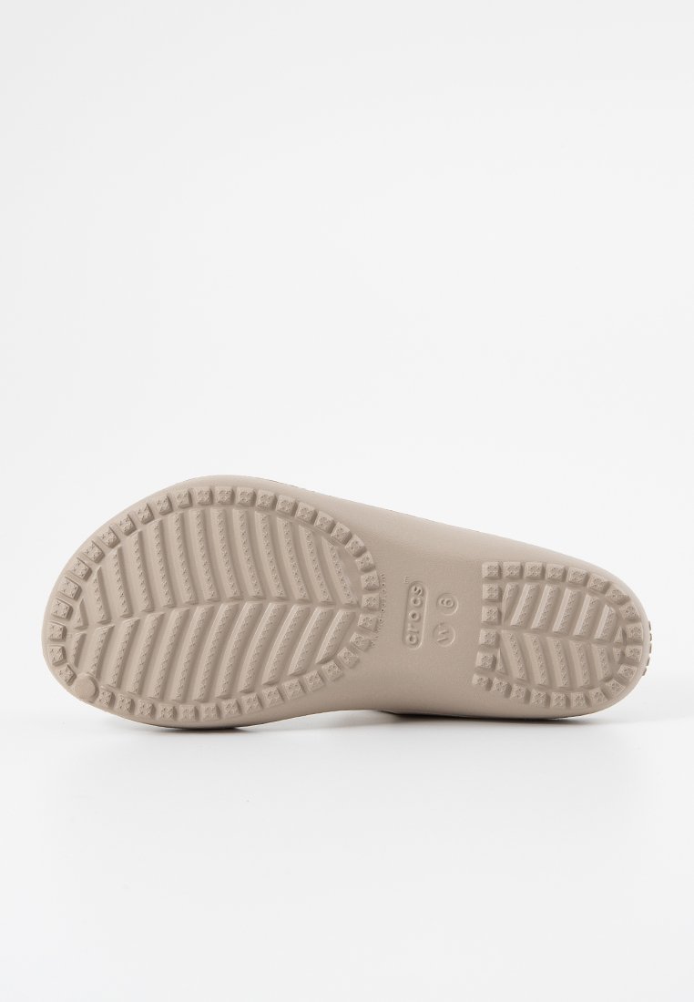 Jasno beżowa guma podeszwy buta z teksturowanym bieżnikiem, który zawiera wzory w zygzaku i okręgu. Oznaczenia obejmują rozmiar "6" oraz nazwę marki.