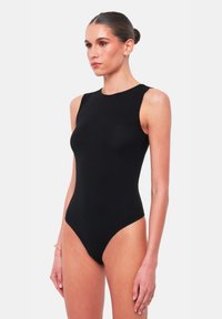 Body aderente senza maniche di colore nero, con colletto alto, design senza cuciture e silhouette aderente, realizzato in un tessuto liscio ed elastico.