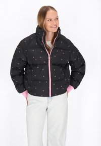 Puffjakke i sort med lyserøde detaljer, udstyret med høj krave, frontlynlås med hjerte vedhæng og broderede blomster mønstre overalt.