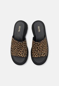Paire de sandales slides noires avec des brides à imprimé léopard et le logo Michael Kors sur des semelles noires rembourrées.