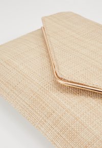 Borsa clutch beige intrecciata con rifiniture in rosa oro metallico, caratterizzata da una superficie testurizzata e chiusura a patta stile busta.