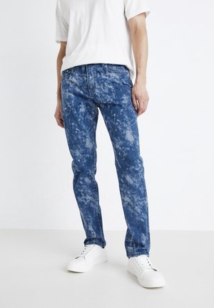 Lett blå denim jeans med et sky-lignende teksturmønster, rett bensdesign og klassisk fem-lomme styling, kombinert med hvite joggesko.