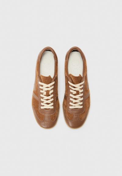 Bruna mocka- och lädersneakers med gräddfärgade snören, rund tå och subtil kontrastsöm. Texturerad ovandel och slät sula.