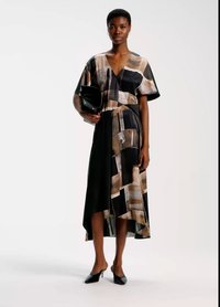 Multi-patterned dress with a V-neck, short sleeves, and an asymmetrical hem. Made of lightweight fabric in shades of black, beige, and white.