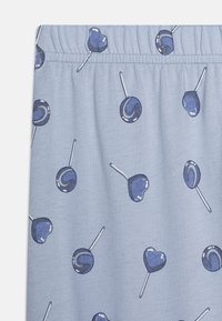 Light blue fabric featuring a repeated pattern of lollipops in dark blue, heart-shaped and round, with white accents and an elastic waistband.