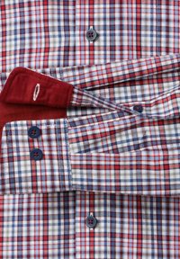 Rote, blaue und weiße karierte Hemd mit Fischgrätenmuster; verfügt über marineblaue Knöpfe und kräftige rote Akzente an den Manschetten und dem Kragen.
