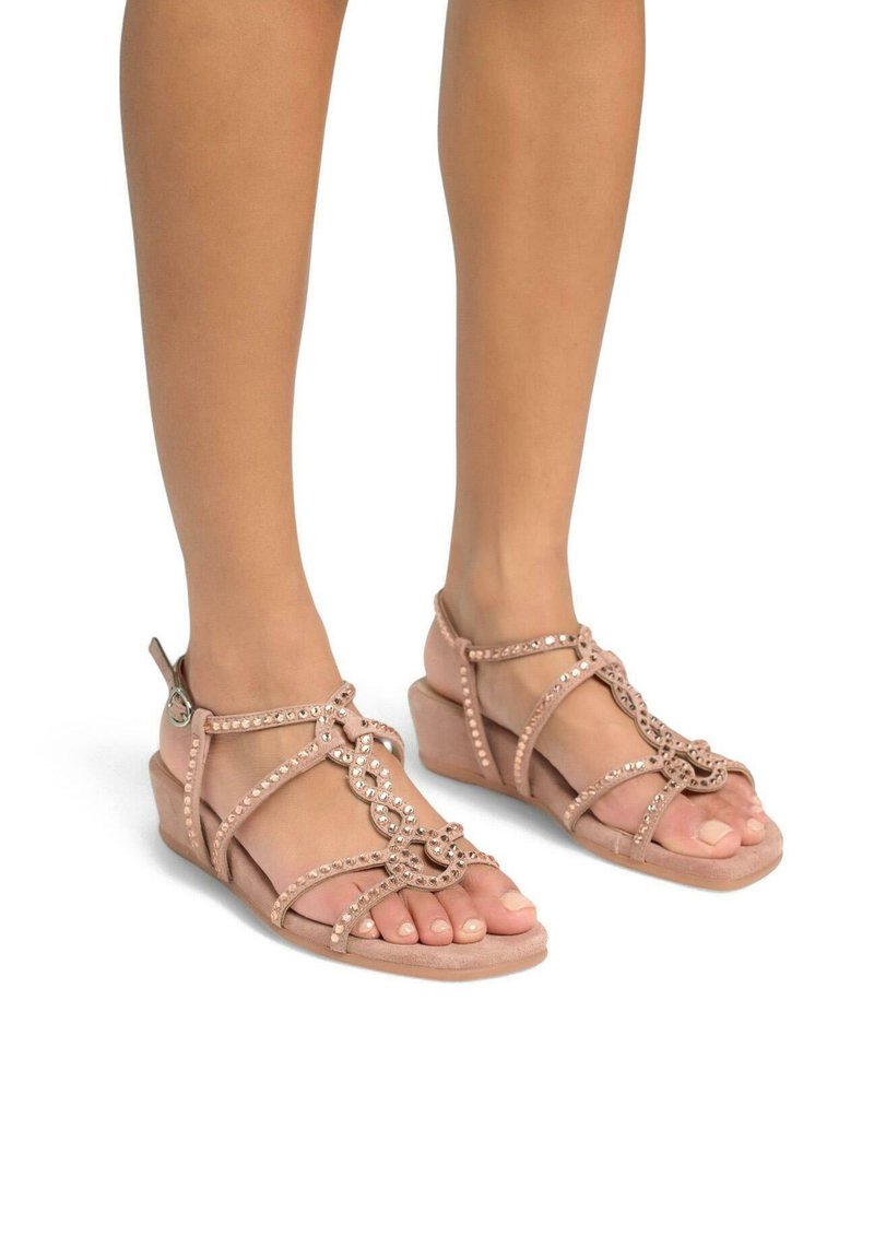 Sandali wedge beige con cinturini incrociati decorati con strass. Materiale morbido e design open-toe migliorano la traspirabilità.