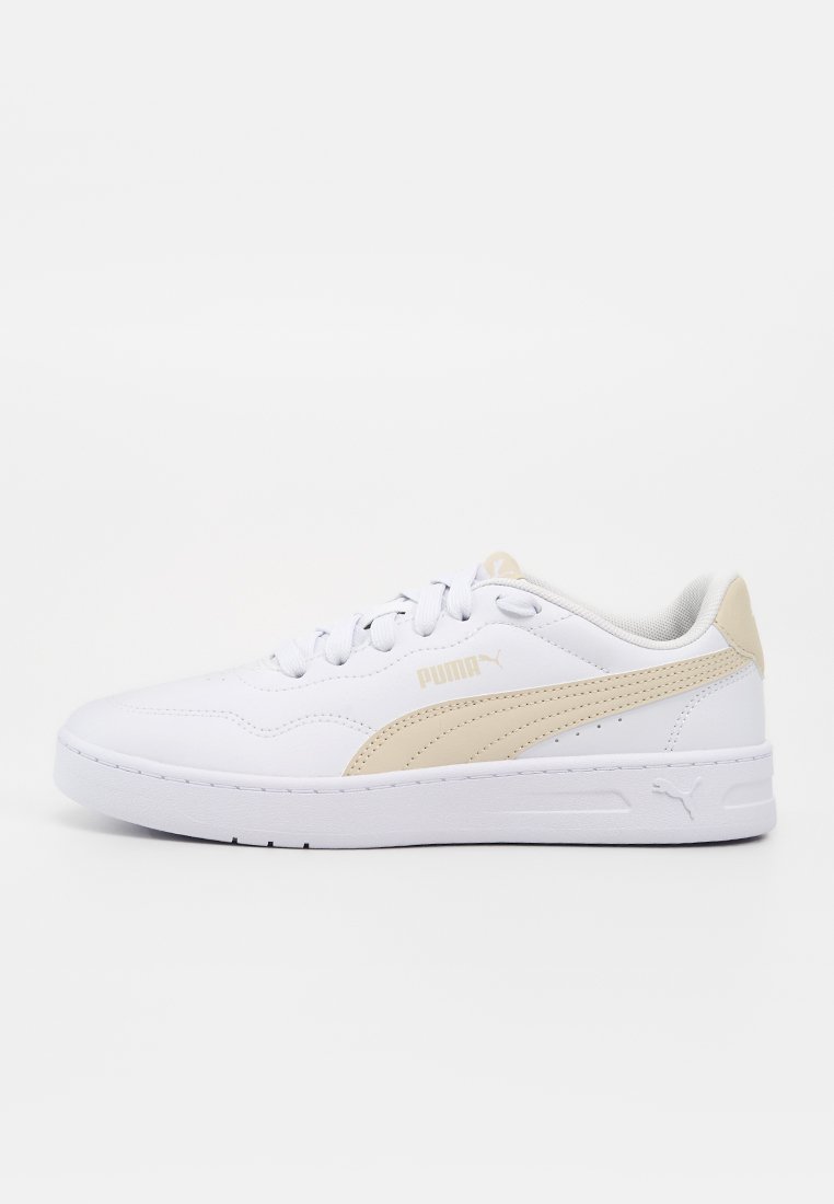 Baskets basses blanches Puma avec bande logo beige, fermeture à lacets et semelle rembourrée, vues de l'extérieur sur un fond uni.