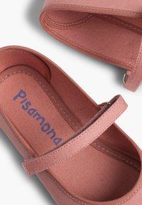 Růžové plátěné slip-on boty se šňůrkou, mají texturovaný povrch a viditelné švy; logo vytištěno na stélce.