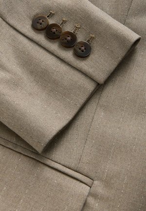 Tissu de blazer marron sur mesure avec des rayures subtiles, doté d'une manche avec quatre boutons assortis et de détails de couture fins.