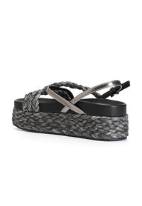 Sandali platform intrecciati neri e grigi con una texture a corda, accenti metallici e design a fascia incrociata su una suola spessa e testurizzata.