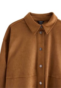 Giacca in finta suede marrone con colletto classico, bottoni a pressione e una texture liscia. Presenta toppe sulle spalle e un taglio dritto.