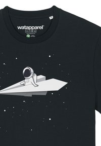 Schwarzes Baumwoll-T-Shirt mit einem Druckdesign eines Astronauten auf einem weißen Papierflugzeug, umgeben von kleinen weißen Sternen.