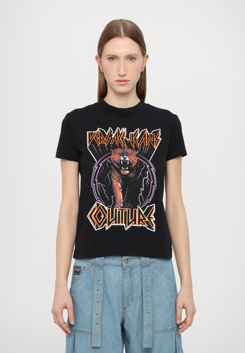 Μαύρο βαμβακερό t-shirt με γραφικό ενός βρυχηθμού τίγρης, περιγραμμένου με πορτοκαλί και μωβ λεπτομέρειες. Στρογγυλή λαιμόκοψη και κοντά μανίκια.