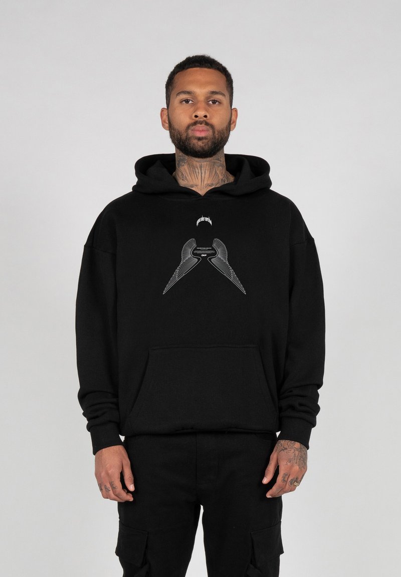 Zwarte hoodie van zacht materiaal met een voorzak en een grafisch ontwerp van gestileerde vleugels op de borst. Inclusief kangoeroezak.