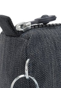 Borsa in tessuto nero con zip, caratterizzata da un motivo diagonale testurizzato, dotata di un dettaglio ad anello metallico e di un'asola in tessuto sulla parte superiore.