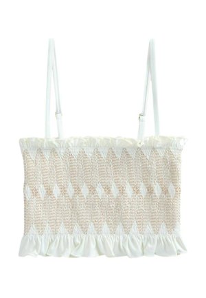 Vävd beige och vit topp med smockad textur och volangkant, med justerbara vita axelremmar. Designen inkluderar diamantmönster.