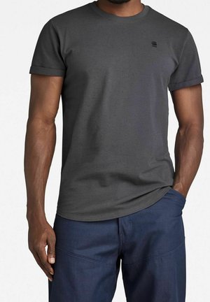 Graues T-Shirt mit kurzen Ärmeln aus einem Baumwoll-Mischgewebe, mit Rundhalsausschnitt und einem kleinen Logo auf der linken Brust. Glatte Textur.