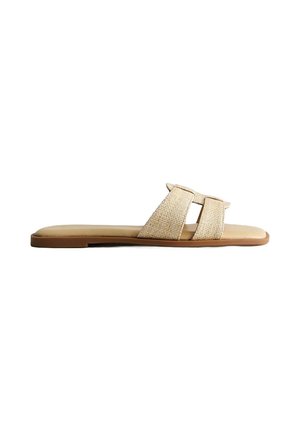 Sandale plate beige à enfiler avec deux larges brides tissées et une semelle lisse sur fond blanc.