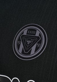 Schwarzer Stoffaufnäher mit einem kreisförmigen Emblem, das die römische Zahl XXIII und ein dreieckiges Design mit einem Bienen-Symbol in der Mitte zeigt.