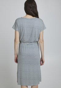 Kurzes Kleid aus leichtem Stoff mit einem geometrischen Muster aus blauen und weißen Dreiecken, tailliert mit einem elastischen Band.