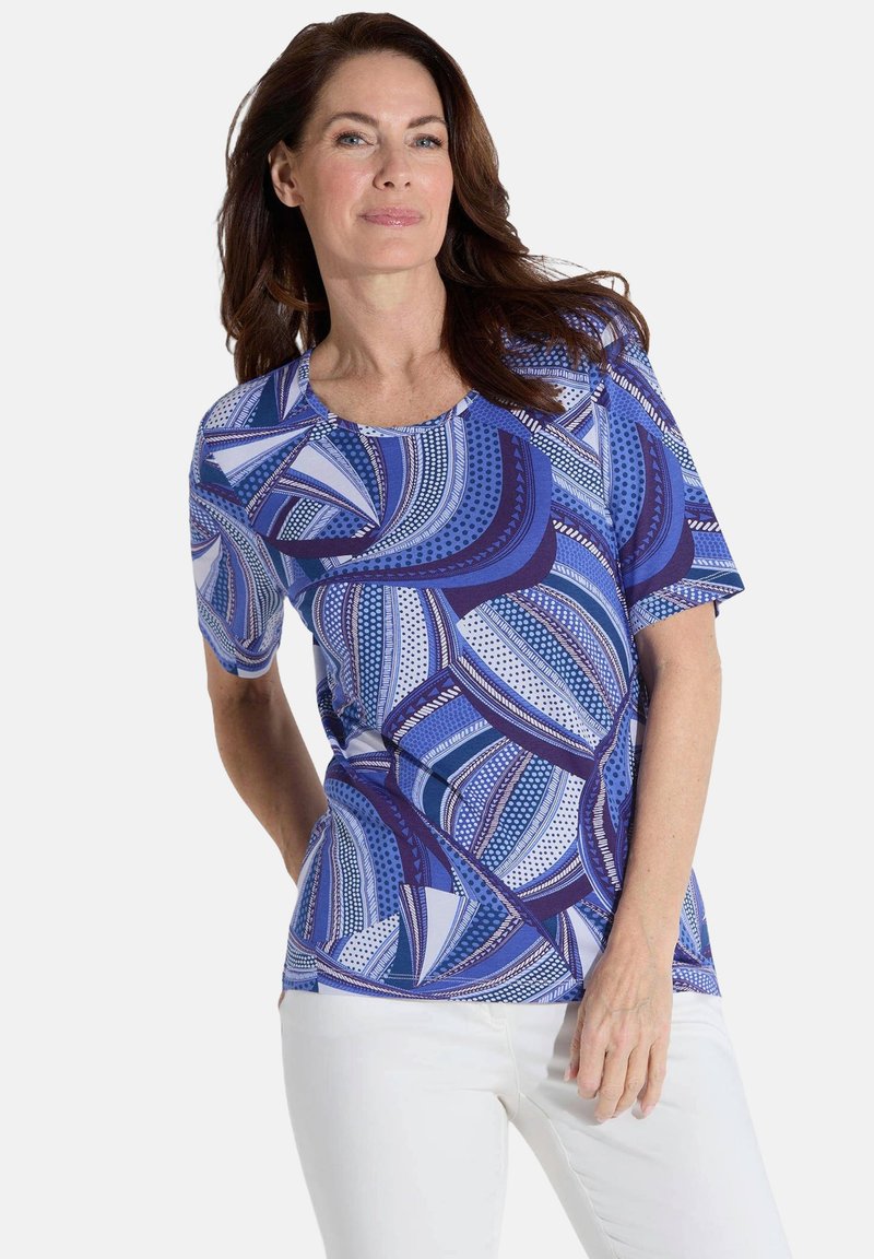 Korte mouw blauwe top met een gedurfd geometrisch patroon in verschillende tinten blauw en wit, met een ronde halslijn en een relaxte pasvorm.
