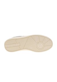 Sole della scarpa di colore crema, con un motivo testurizzato per una migliore presa e un marchio che reca la scritta "MUSTANG". Emblema circolare con un dettaglio di design.