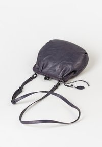 Borsa in pelle viola con una texture morbida, forma arrotondata, dettagli in catena e tracolla, e una chiusura a scatto. Presenta un piccolo tag attaccato.