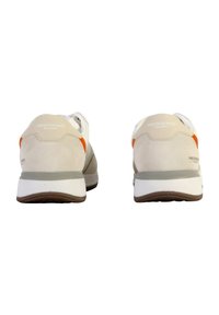 Beige sportssko med hvide accenter, der har et glat mesh-materiale og en tekstureret gummisål. Orange detaljer på hælen.