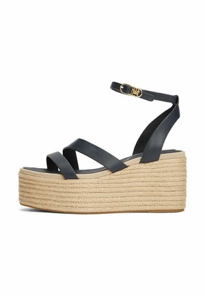 Black leather wedge sandals with crisscross straps and a braided rope platform. Features an ankle strap and gold-tone buckle detailing.