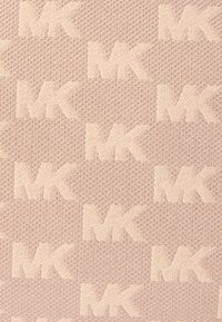 Tissu texturé rose clair présentant un motif en relief de logos "MK" répétés dans un agencement uniforme sur toute la surface.