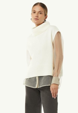 White knit sleeveless turtleneck sweater with wide collar and ribbed hem, layered over a sheer beige long-sleeve shirt with gray accents.