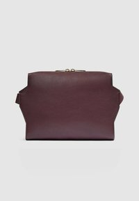 Bolso de mano de cuero burdeos con superficie texturizada, diseño angular y cierre de tono dorado. Cuenta con una asa lateral para llevar.